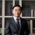 91视内容总监陈明远，专业西装正装照，背景为简洁米色书架，气质沉稳专业